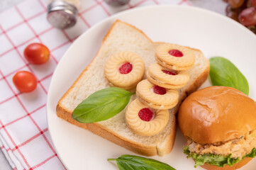 Bread slices, stuffed buns, and burgers on a white plate.