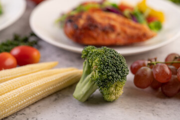 Broccoli, baby corn, grapes and tomatoes on white