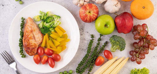 Chicken steak topped with white sesame, peas, tomatoes, broccoli and pumpkin in a white plate.