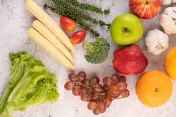 Apple, orange, Broccoli, baby corn, grapes and tomatoes on white