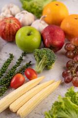 Apple, orange, Broccoli, baby corn, grapes and tomatoes on white