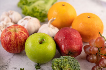 Apple, orange, Broccoli, baby corn, grapes and tomatoes on white