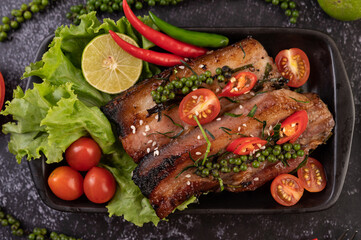 Sliced ​​pork steak topped with white sesame and fresh pepper seeds along.