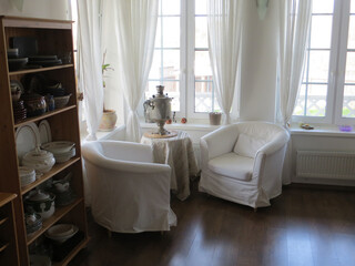 samovar on a round table covered with a tablecloth in a light room near the window, selective focus