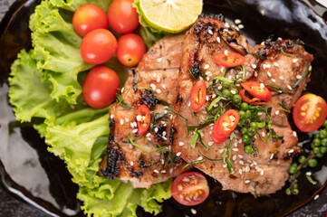 Sliced ​​pork steak topped with white sesame and fresh pepper seeds along.