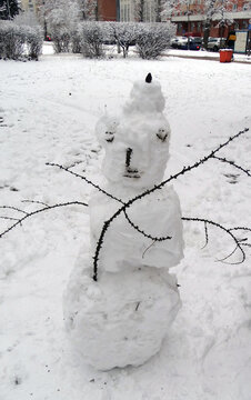 snowman with hands from sticks in winter snow park