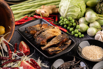 Deep-fried fish slices in a black plate.