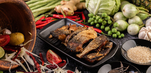 Deep-fried fish slices in a black plate.