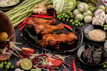 Three pieces of fried chicken on a black plate.