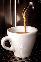 primer plano de taza de cafe con crema y maquina expres