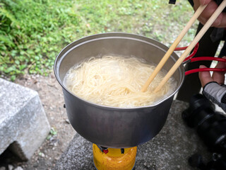 アウトドア調理　麺を湯がくシーン
