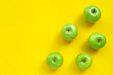 Green apples on yellow background.