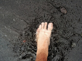 Bare Feet Walking on Black Sand and Clear Sea Waves