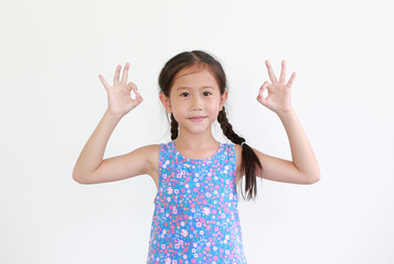 Cheerful asian little kid girl showing finger ok symbol sign language isolated over white background