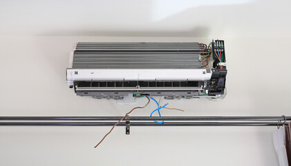 A new air conditioner installation on white wall is in progress. Open the lid.