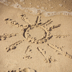 Shape of sun on sand at beach and incoming sea wave. Summer, vacation time and tourism