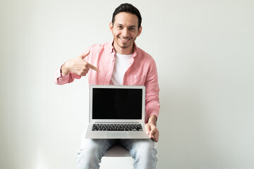 Hispanic man pointing at laptop screen