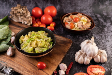Stir the white cabbage with oyster sauce on a black plate.