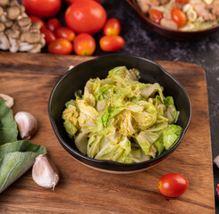 Stir the white cabbage with oyster sauce on a black plate.