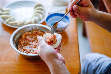 A person is making dumplings, traditional Chinese food