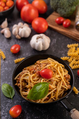 Spaghetti sauteed in a pan-fried with tomatoes and basil