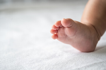 Baby feet in white bed.