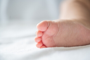 Baby feet in white bed.