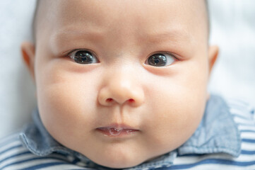 A newborn baby who opens his eyes and looks forward
