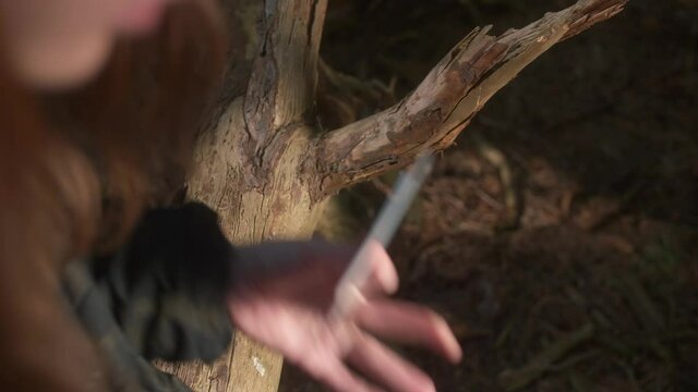 Survival girl in forest looking at the map and plans a route
