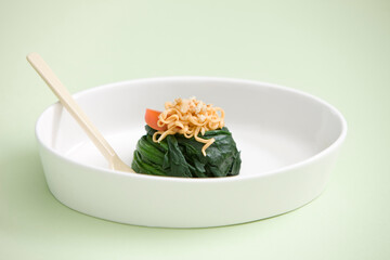 seasoned spinach topped with noodle