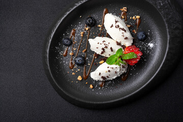 Dessert in oval plate, vanilla ice cream, blueberry, strawberry, caramel sauce
