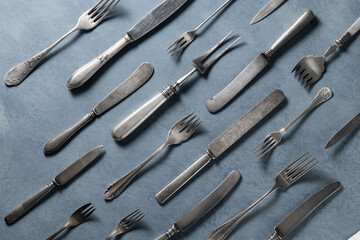 old rusty metal background. a lot of old salt utensils, knives, forks. As a pattern on a uniform background