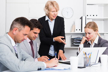 Business woman feeling angry to coworkers in office, pointing out mistakes in work.