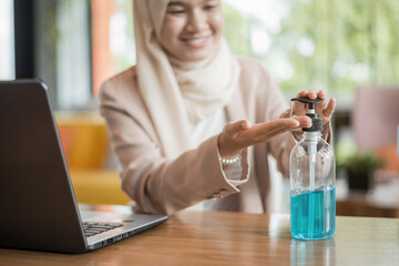 Close up of hands muslim woman cleaning her hands with alcohol gel.