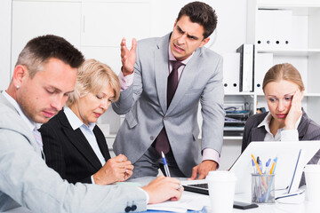 Businessman feeling angry to coworkers in office, pointing out mistakes in work