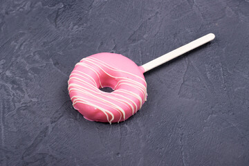 pink doughnuts on a stick on a black table