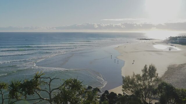People Walking On The Beach Shore Of Snapper Rocks On A Sunrise - Waves On The Blue Ocean - Rainbow Bay - Gold Coast, Queensland, Australia. - wide shot