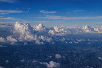Fototapeta premium cityscape view from airplane with cloudy blue sky above, photo may has some noise