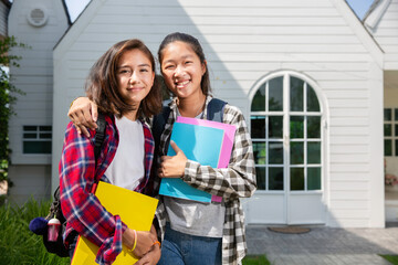 Two teenage asia and european student friends girls happy going to college or school