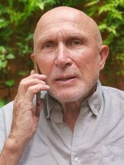 Un homme agé discute au telrphonne mobile.