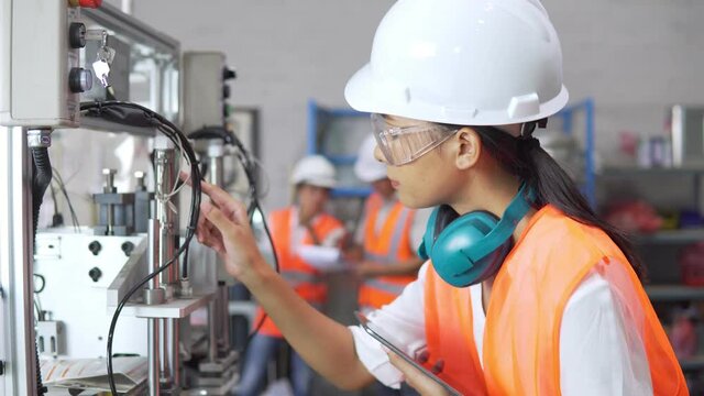 Footage B-roll of Female factory worker technician check a machine. Business Women engineering holding tablet check product quality. Smart Technology. Industrial working concept. Business industrial
