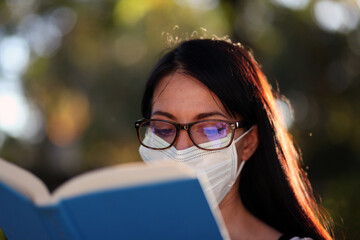 Business Woman working outside in a park wearing a mask, social distancing during a pandemic 