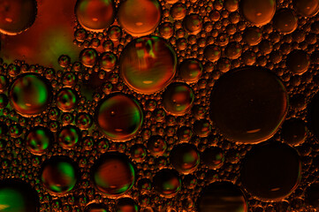 Artistic photo of oil drops close up in red tones for background