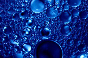 Artistic photo of oil drops close up in blue tones for background