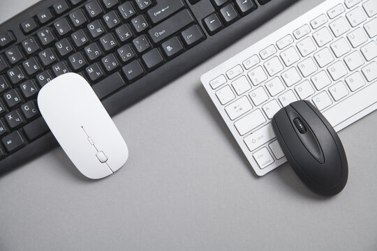 Computer keyboard and mouse on grey background.