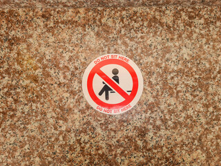 No sit sign sign stuck on marble surface