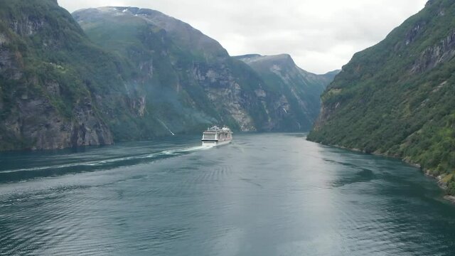 Cruise ship sailing away in Norway Geiranger