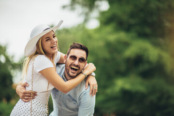 Happy young couple laughing and have fun at city park.