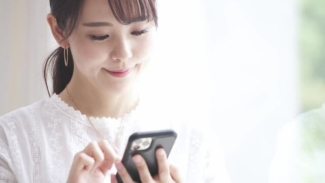スマートフォンを操作している若い女性