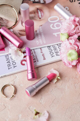 Obraz na płótnie Canvas Different lipsticks, fashion magazines and bijouterie on table